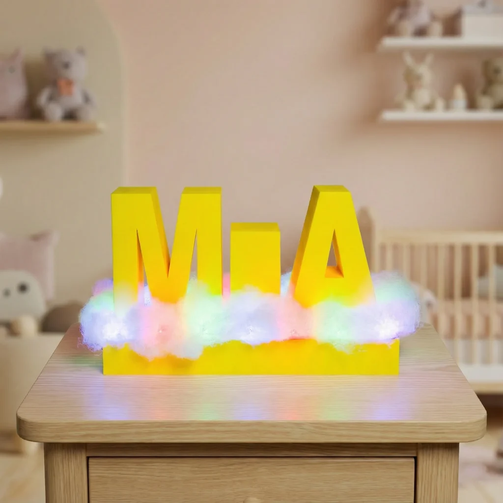 Žuta 3D printana noćna lampica s imenom Mia na oblačnoj LED podlozi u dječjoj sobi